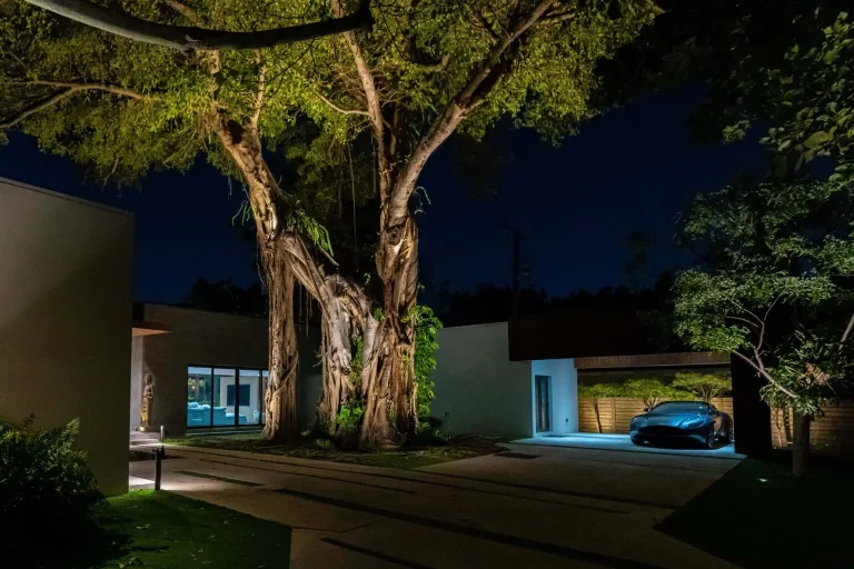 Warm landscape lighting illuminating a Miami Shores outdoor living space at night